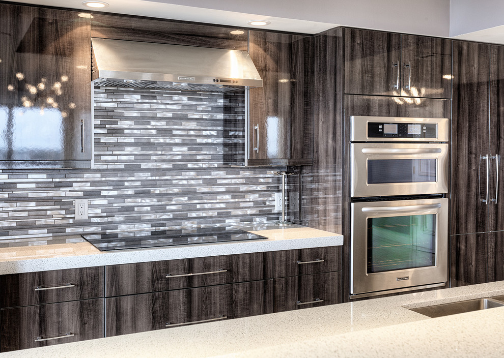 Exempel på ett modernt kök och matrum, med en undermonterad diskho, släta luckor, skåp i mörkt trä, bänkskiva i kvartsit, stänkskydd med metallisk yta, stänkskydd i stenkakel, rostfria vitvaror, marmorgolv och en köksö