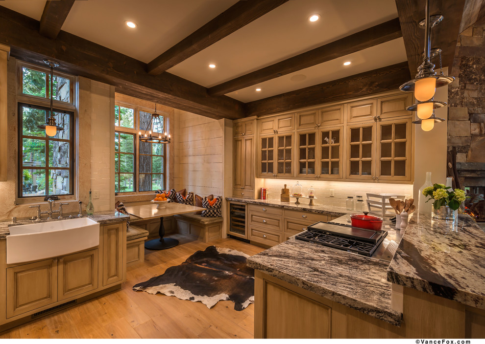 Inredning av ett rustikt mellanstort kök, med en rustik diskho, luckor med upphöjd panel, skåp i ljust trä, granitbänkskiva, vitt stänkskydd, stänkskydd i stenkakel, rostfria vitvaror, ljust trägolv och en halv köksö