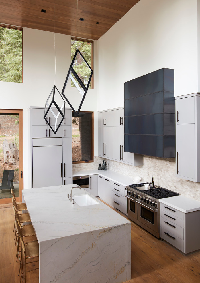 Inspiration för stora moderna kök, med en undermonterad diskho, släta luckor, grå skåp, marmorbänkskiva, beige stänkskydd, stänkskydd i keramik, rostfria vitvaror, mellanmörkt trägolv, en köksö och brunt golv