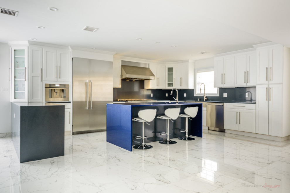 Exempel på ett stort modernt blå blått kök, med en rustik diskho, luckor med infälld panel, vita skåp, bänkskiva i kvarts, svart stänkskydd, rostfria vitvaror, marmorgolv, en köksö och flerfärgat golv