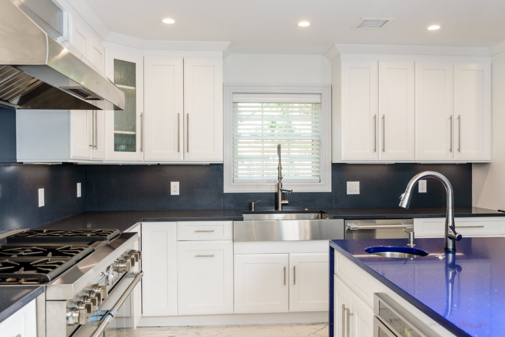 Idéer för att renovera ett stort funkis blå blått kök, med en rustik diskho, luckor med infälld panel, vita skåp, bänkskiva i kvarts, svart stänkskydd, rostfria vitvaror, marmorgolv, en köksö och flerfärgat golv