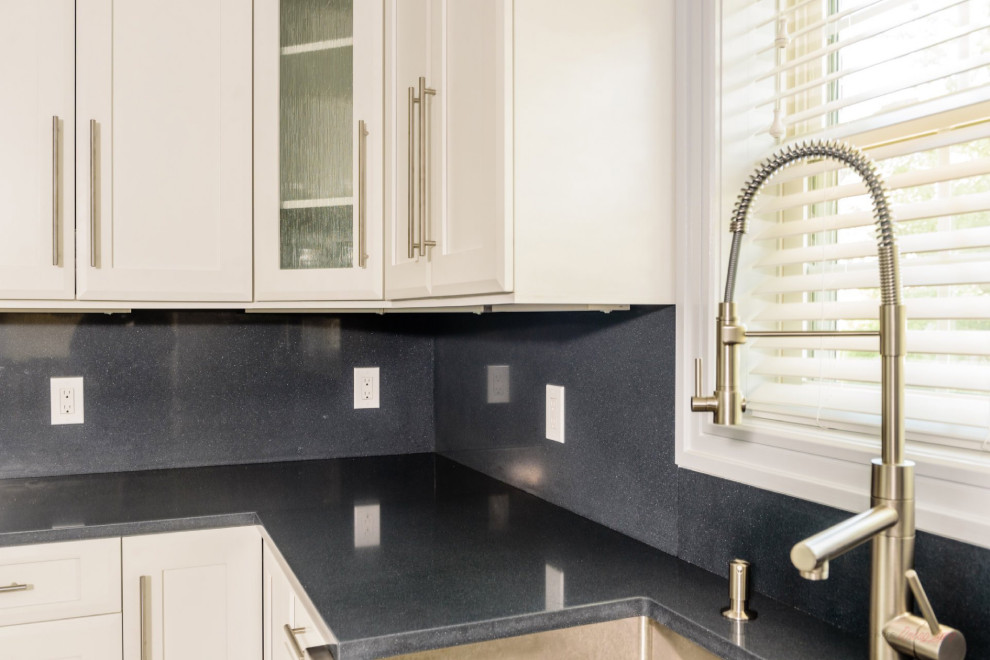 Modern inredning av ett stort blå blått kök, med en rustik diskho, luckor med infälld panel, vita skåp, bänkskiva i kvarts, svart stänkskydd, rostfria vitvaror, marmorgolv, en köksö och flerfärgat golv