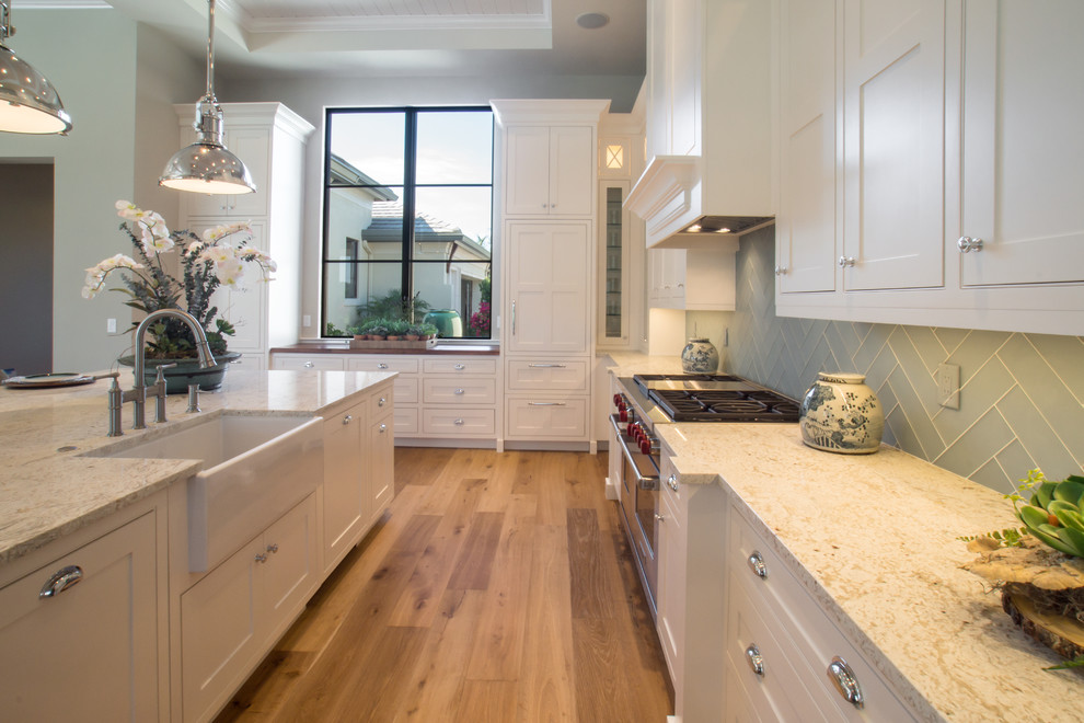 Example of a large transitional l-shaped eat-in kitchen design in Miami with shaker cabinets, white cabinets, granite countertops, green backsplash, an island and paneled appliances