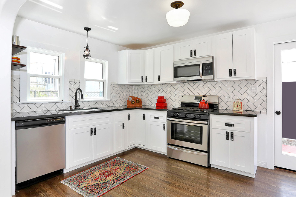 Photo of a classic kitchen in Los Angeles with a submerged sink, shaker cabinets, white cabinets, granite worktops, white splashback, metro tiled splashback and stainless steel appliances.