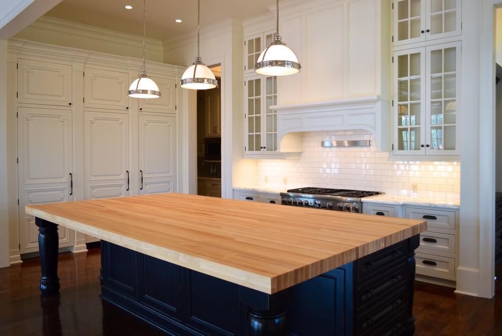 Eat-in kitchen - large transitional u-shaped medium tone wood floor eat-in kitchen idea in Houston with flat-panel cabinets, white cabinets, wood countertops, white backsplash and paneled appliances