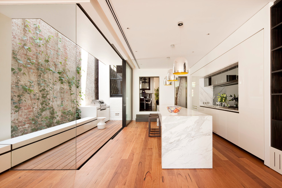 Стильный дизайн: кухня в стиле модернизм с плоскими фасадами, белыми фасадами и островом - последний тренд