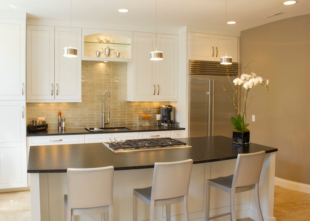 Classic galley kitchen in Chicago with an island, a submerged sink and white cabinets.