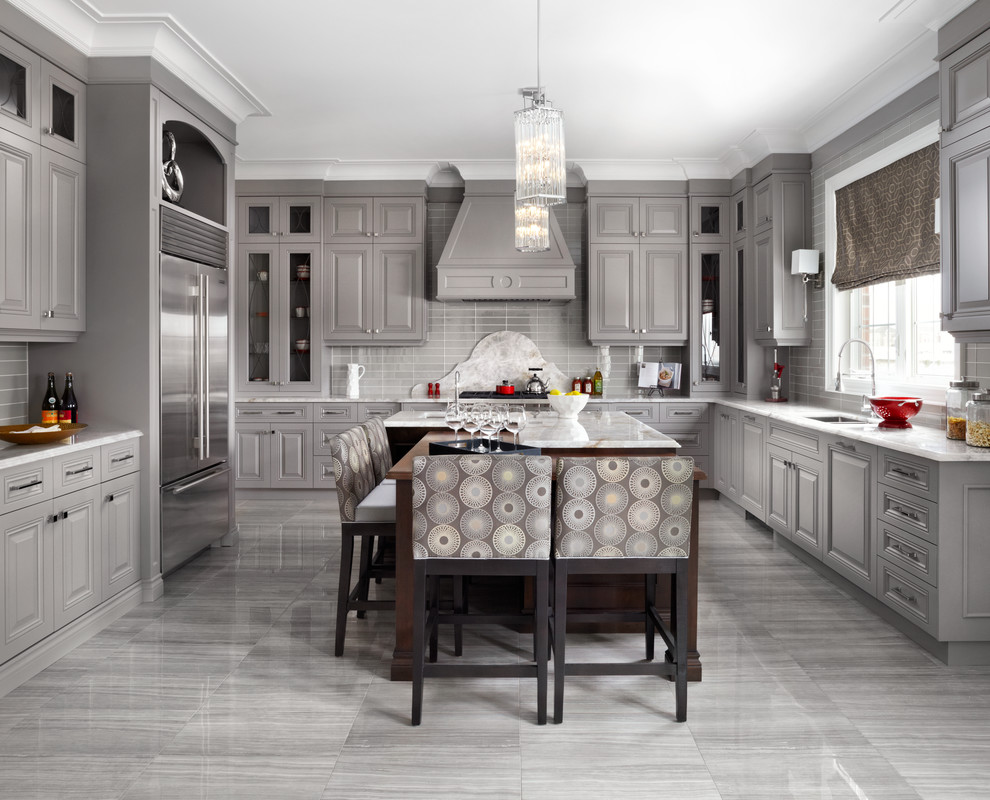 Photo of a traditional u-shaped kitchen in Toronto with a submerged sink, raised-panel cabinets, grey cabinets, grey splashback, stainless steel appliances and an island.