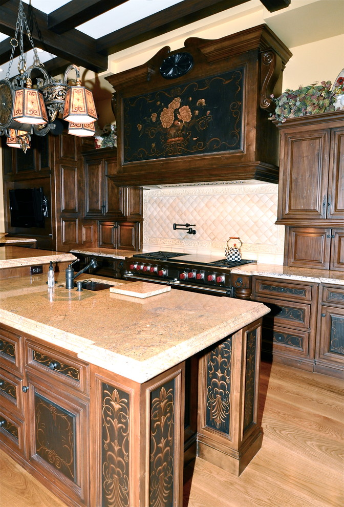 Exemple d'une cuisine ouverte chic en L et bois brun avec un placard avec porte à panneau encastré, un plan de travail en granite, une crédence beige, une crédence en céramique, parquet clair et îlot.