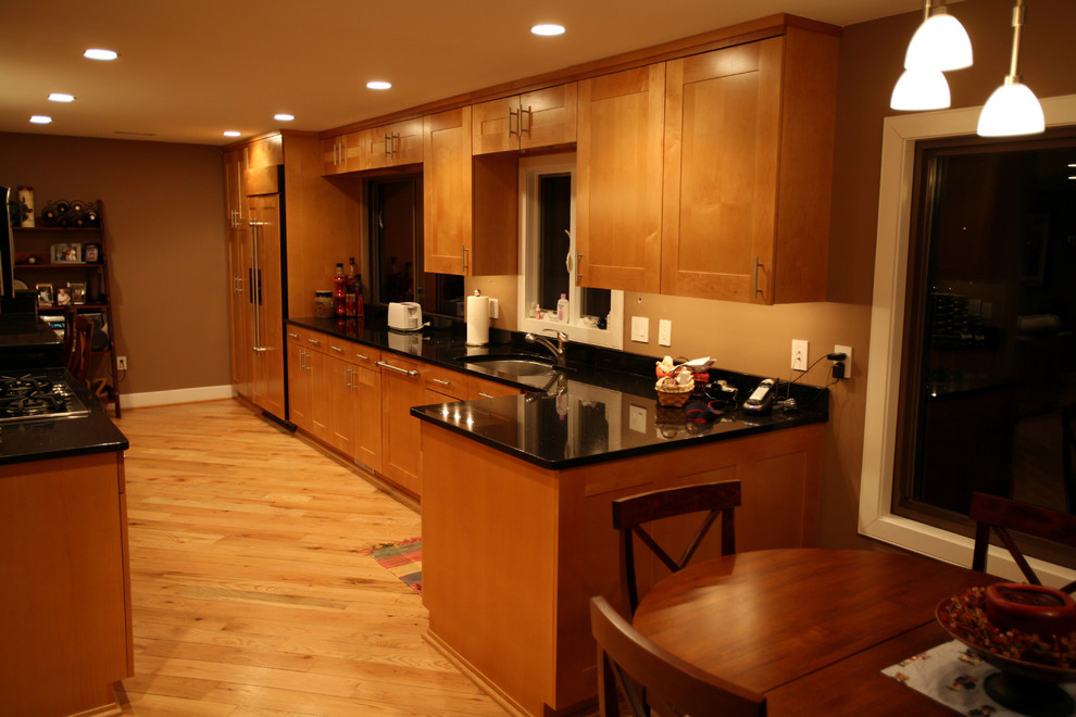Пример оригинального дизайна: параллельная кухня среднего размера в стиле кантри с обеденным столом, фасадами в стиле шейкер, светлыми деревянными фасадами, гранитной столешницей и полуостровом