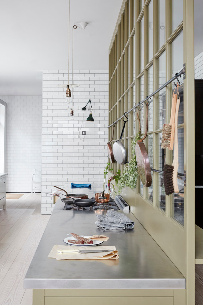 Klassische Küche mit Edelstahl-Arbeitsplatte und hellem Holzboden in London