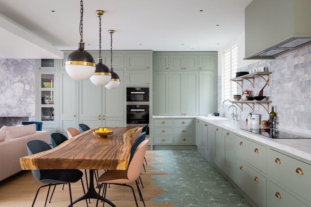 ロンドンにあるトランジショナルスタイルのおしゃれなキッチン (シェーカースタイル扉のキャビネット、緑のキャビネット、大理石のキッチンパネル、黒い調理設備、緑の床、白いキッチンカウンター、窓) の写真