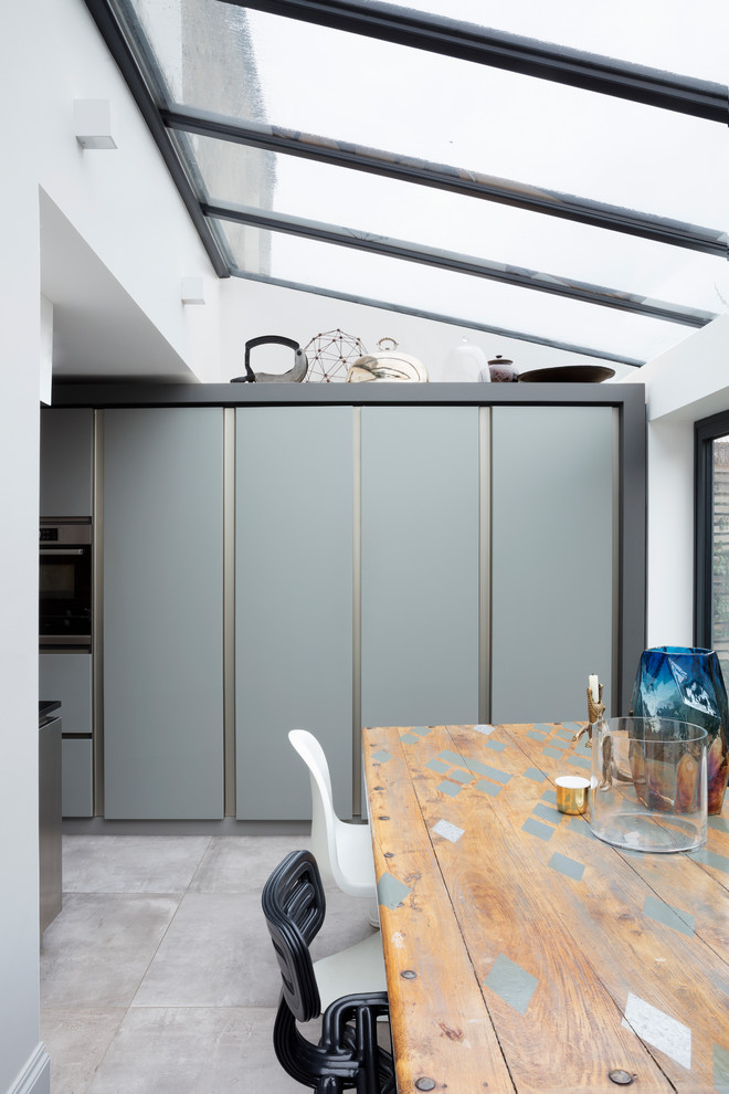 This is an example of a large contemporary single-wall kitchen/diner in London with recessed-panel cabinets, stainless steel cabinets and an island.