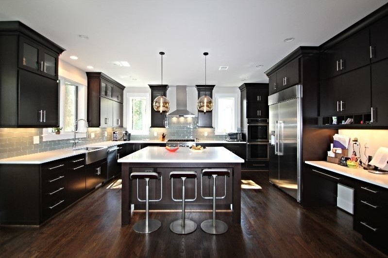 Inspiration for a mid-sized contemporary u-shaped eat-in kitchen remodel in DC Metro with a farmhouse sink, flat-panel cabinets, dark wood cabinets, solid surface countertops, stainless steel appliances and two islands
