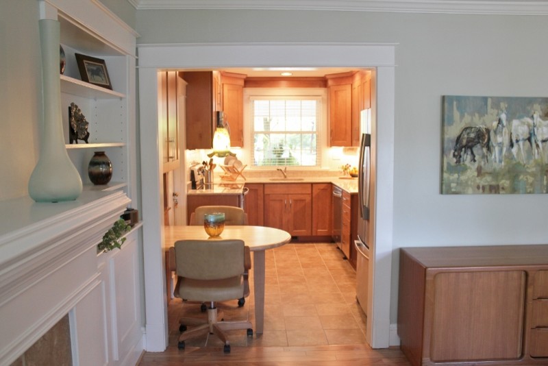 Example of a small danish u-shaped porcelain tile eat-in kitchen design in Other with an undermount sink, shaker cabinets, light wood cabinets, solid surface countertops, white backsplash, porcelain backsplash, stainless steel appliances and a peninsula