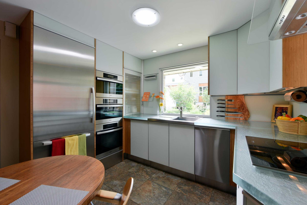This is an example of a small contemporary u-shaped kitchen/diner in Ottawa with a built-in sink, glass-front cabinets, white cabinets, glass worktops, white splashback, glass sheet splashback, stainless steel appliances, porcelain flooring, no island, multi-coloured floors and white worktops.