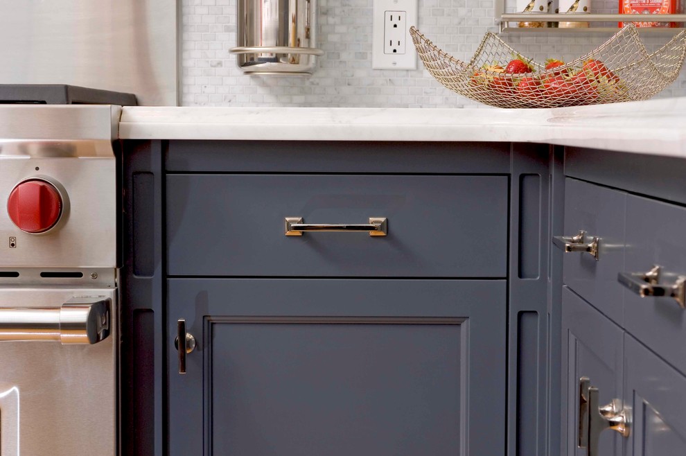 Bild på ett mellanstort funkis kök, med en undermonterad diskho, skåp i shakerstil, blå skåp, bänkskiva i kvarts, grått stänkskydd, stänkskydd i glaskakel, rostfria vitvaror, ljust trägolv och en halv köksö