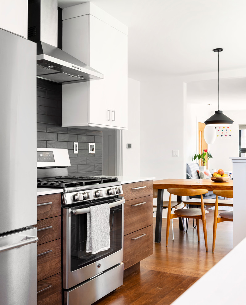 Mid-sized trendy galley medium tone wood floor eat-in kitchen photo in Seattle with an undermount sink, flat-panel cabinets, white cabinets, quartz countertops, gray backsplash, subway tile backsplash, stainless steel appliances, no island and white countertops