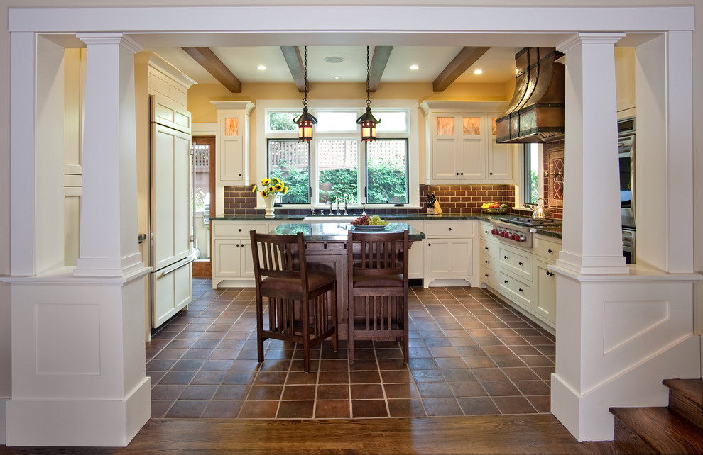 Idéer för att renovera ett stort amerikanskt kök, med en rustik diskho, luckor med upphöjd panel, vita skåp, marmorbänkskiva, brunt stänkskydd, stänkskydd i tunnelbanekakel, rostfria vitvaror, klinkergolv i terrakotta, en köksö och brunt golv