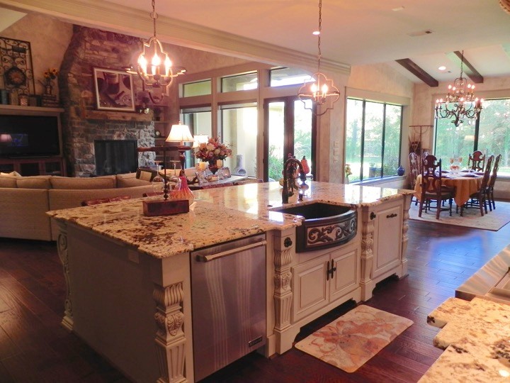 Exempel på ett medelhavsstil kök, med granitbänkskiva, mellanmörkt trägolv, en köksö, en rustik diskho och rostfria vitvaror