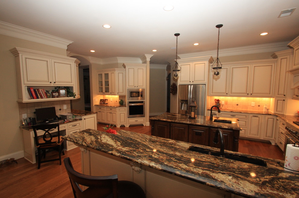 Photo of a medium sized classic u-shaped open plan kitchen in Raleigh with a submerged sink, raised-panel cabinets, beige cabinets, granite worktops, beige splashback, stone tiled splashback, stainless steel appliances, medium hardwood flooring, an island and brown floors.
