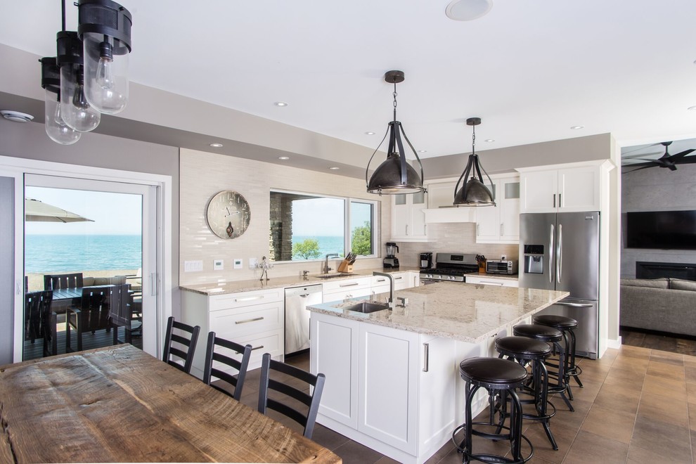 Mid-sized urban l-shaped ceramic tile and brown floor eat-in kitchen photo in Toronto with an undermount sink, shaker cabinets, white cabinets, granite countertops, beige backsplash, subway tile backsplash, stainless steel appliances and an island