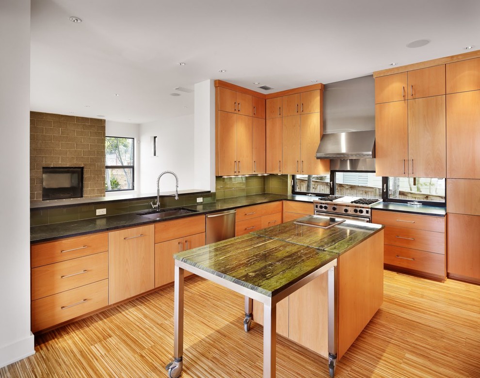 Moderne Küche mit Küchengeräten aus Edelstahl und grüner Arbeitsplatte in Austin