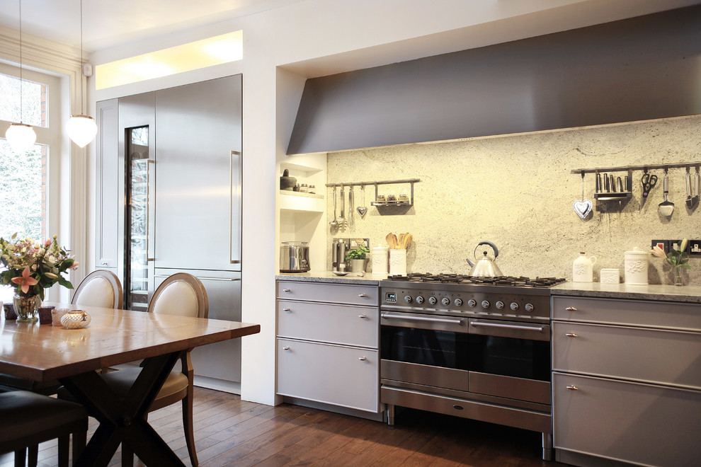Exemple d'une cuisine américaine chic avec des portes de placard grises et un électroménager en acier inoxydable.