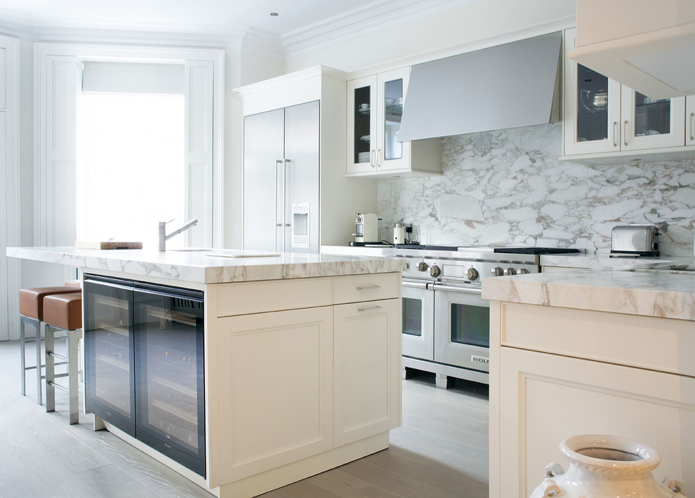 Example of a trendy kitchen design in London with stainless steel appliances, white backsplash and marble backsplash
