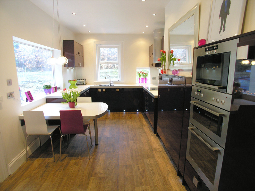 Foto de cocina comedor clásica con fregadero de doble seno, armarios con paneles lisos, puertas de armario negras y electrodomésticos de acero inoxidable