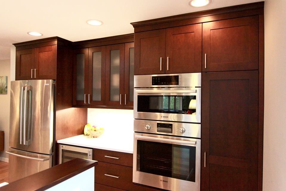 Exempel på ett mellanstort klassiskt kök med öppen planlösning, med en undermonterad diskho, skåp i shakerstil, skåp i mörkt trä, bänkskiva i kvartsit, vitt stänkskydd, stänkskydd i porslinskakel, rostfria vitvaror, ljust trägolv och en köksö