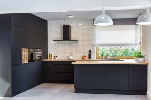 Modern minimalist kitchen in Canada with premium RTA cabinets in matte black finish, wood countertops, and white subway tile backsplash.