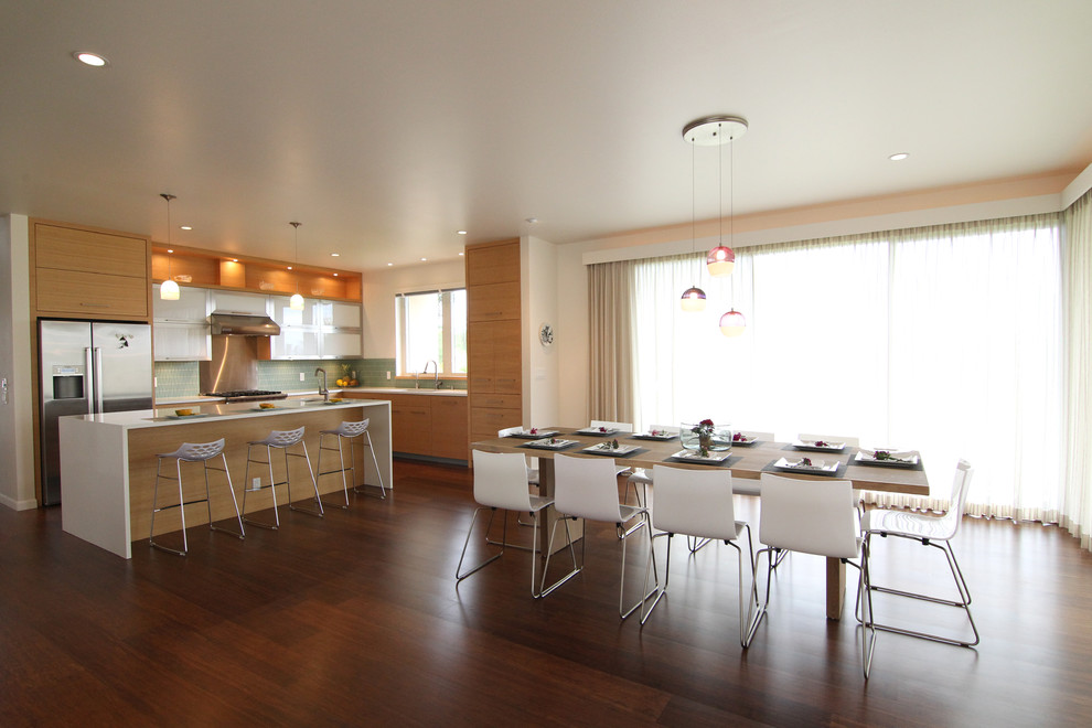 Стильный дизайн: параллельная, глянцевая кухня в стиле модернизм с обеденным столом, плоскими фасадами и светлыми деревянными фасадами - последний тренд