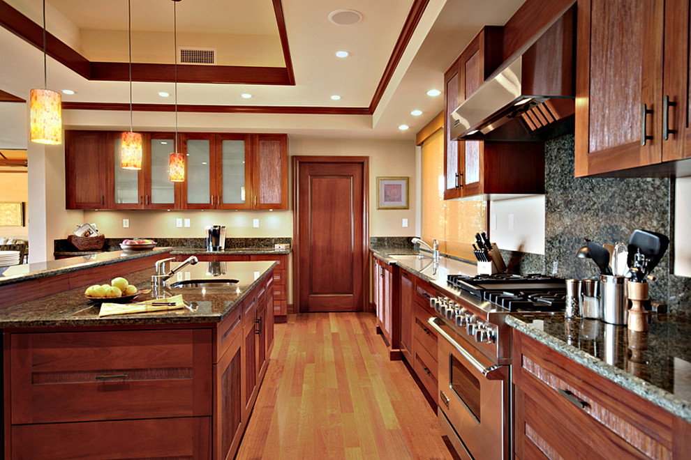 Eat-in kitchen - large tropical u-shaped medium tone wood floor and beige floor eat-in kitchen idea in Hawaii with an undermount sink, recessed-panel cabinets, medium tone wood cabinets, granite countertops, green backsplash, stainless steel appliances and an island