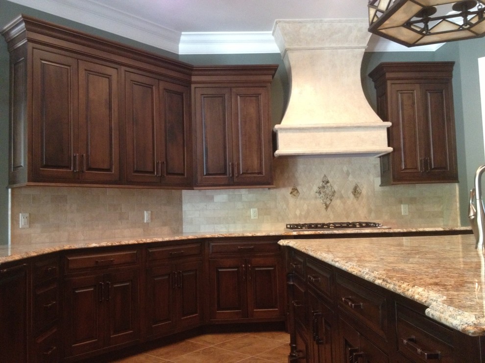 Example of a classic u-shaped eat-in kitchen design in Other with an undermount sink, beaded inset cabinets, medium tone wood cabinets, granite countertops, beige backsplash, stone tile backsplash and paneled appliances