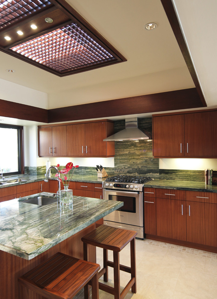Immagine di una cucina design con ante lisce, paraspruzzi verde, paraspruzzi in lastra di pietra e elettrodomestici in acciaio inossidabile