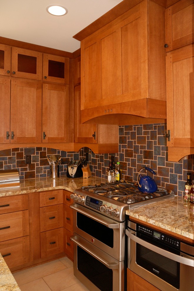 Bild på ett stort amerikanskt kök, med en undermonterad diskho, skåp i shakerstil, skåp i mellenmörkt trä, granitbänkskiva, brunt stänkskydd, stänkskydd i keramik, rostfria vitvaror och klinkergolv i porslin