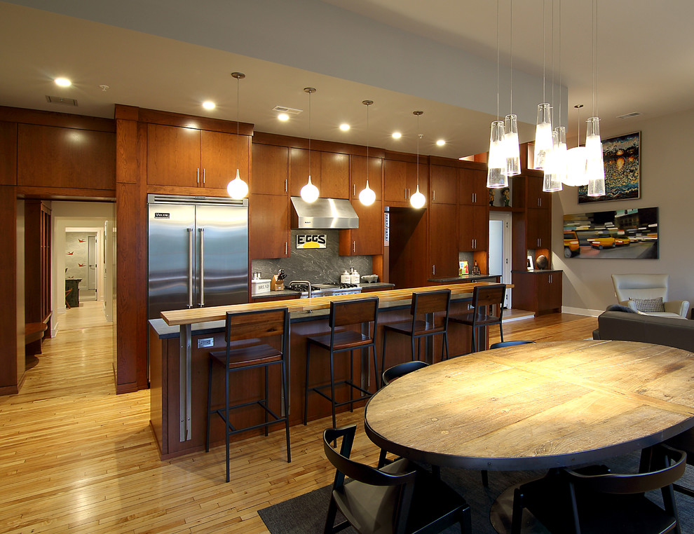 Esempio di una cucina moderna di medie dimensioni con ante lisce, ante in legno bruno, top in cemento, paraspruzzi grigio, paraspruzzi in lastra di pietra, elettrodomestici in acciaio inossidabile e parquet chiaro