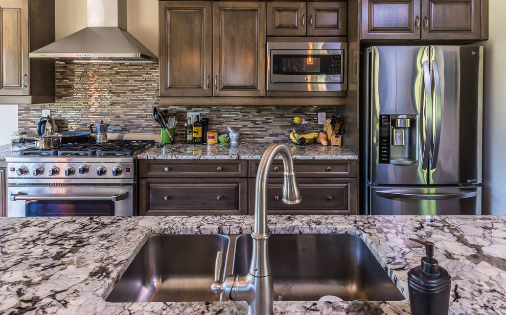 Open concept kitchen - transitional open concept kitchen idea in Toronto with a double-bowl sink, raised-panel cabinets, dark wood cabinets, marble countertops, multicolored backsplash, matchstick tile backsplash, stainless steel appliances and an island