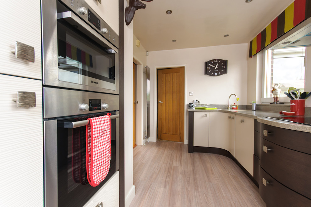 Small contemporary galley enclosed kitchen in Other with an integrated sink, beige cabinets, wood worktops, multi-coloured splashback, stainless steel appliances and no island.