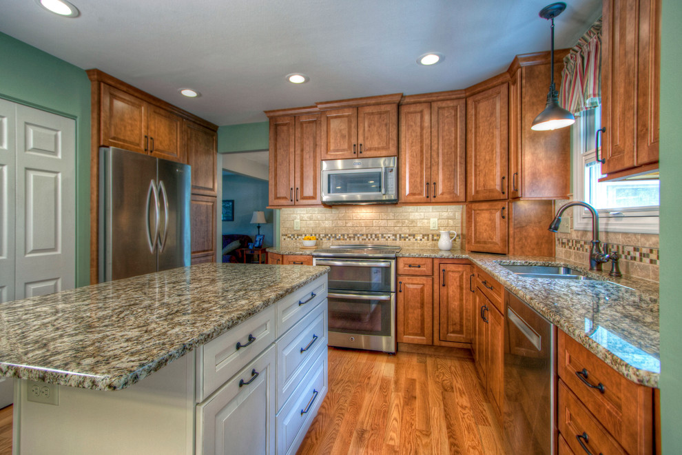 Example of a large classic u-shaped light wood floor eat-in kitchen design in St Louis with a double-bowl sink, raised-panel cabinets, medium tone wood cabinets, granite countertops, beige backsplash, ceramic backsplash, stainless steel appliances and an island