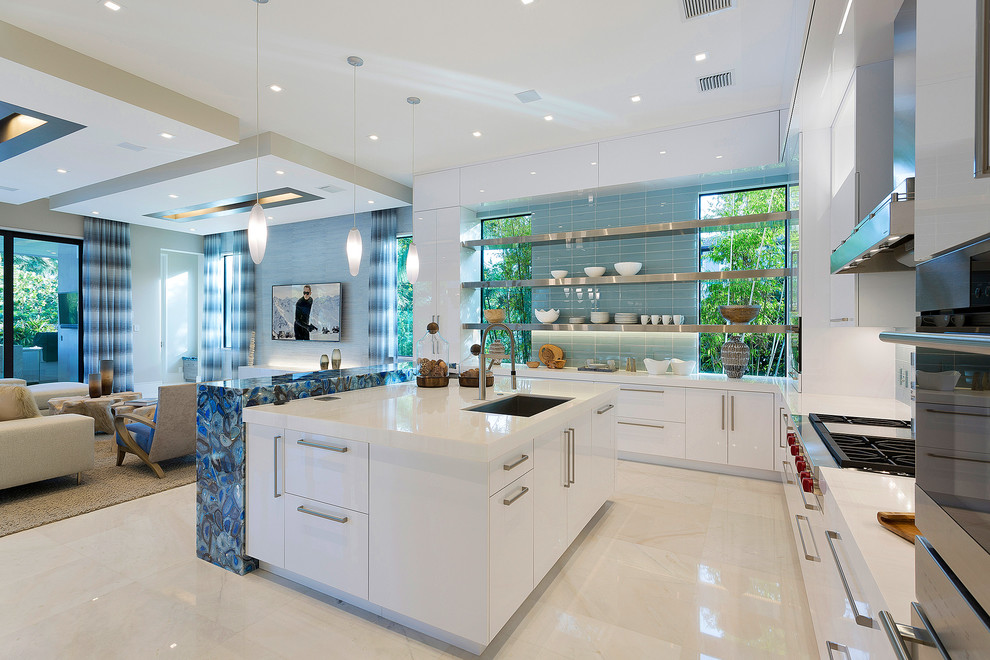 Inspiration for a contemporary l-shaped beige floor open concept kitchen remodel in Other with flat-panel cabinets, white cabinets, blue backsplash, glass tile backsplash, stainless steel appliances and an island