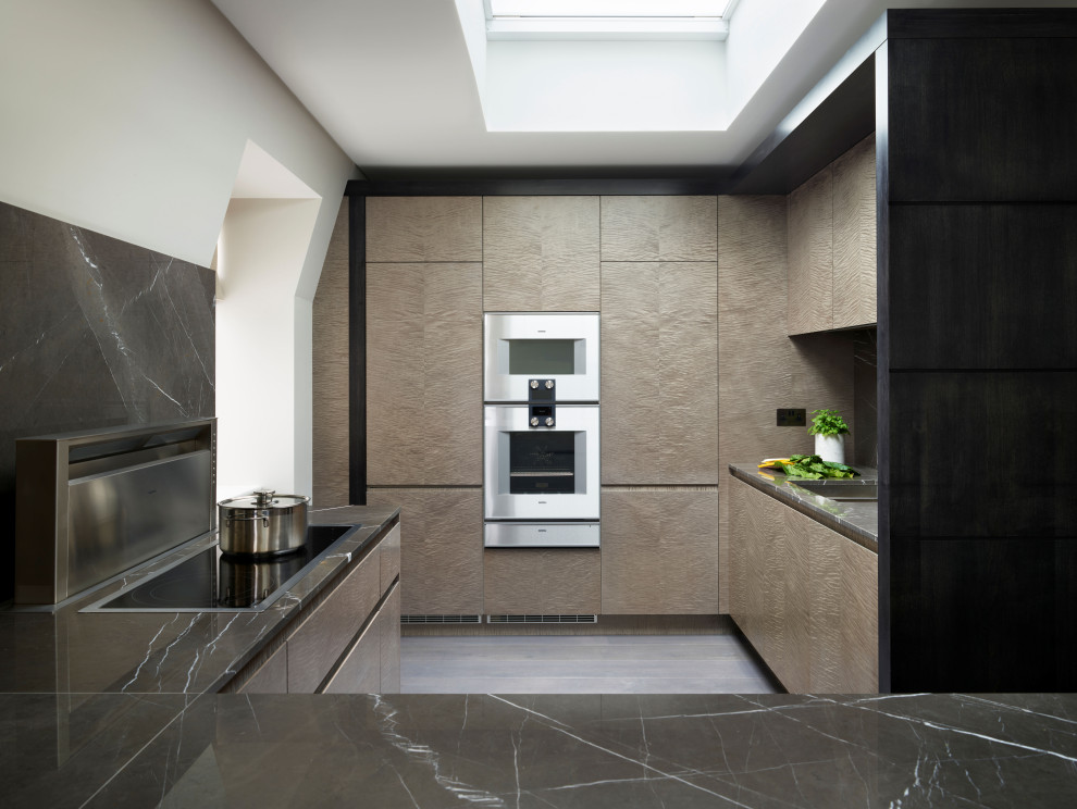 Ispirazione per una cucina moderna di medie dimensioni con lavello integrato, ante lisce, ante in legno chiaro, top in marmo, penisola e top marrone