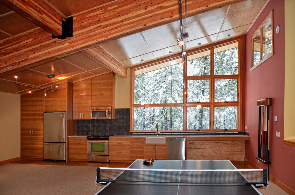 Idée de décoration pour une cuisine linéaire design en bois brun avec un évier de ferme, un placard à porte plane, une crédence noire et un électroménager en acier inoxydable.