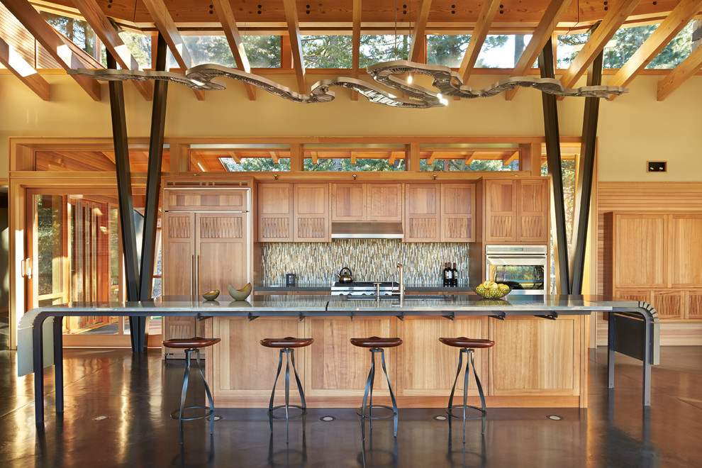 Идея дизайна: большая параллельная кухня-гостиная в современном стиле с врезной мойкой, фасадами цвета дерева среднего тона, стеклянной столешницей, фартуком из стеклянной плитки, техникой под мебельный фасад, бетонным полом и островом