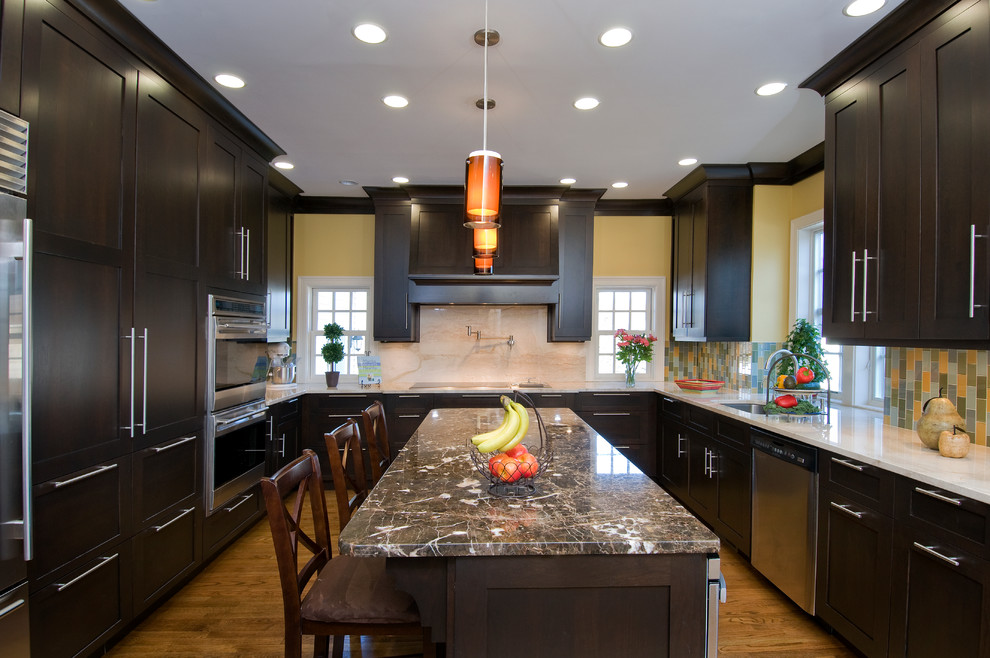 Idée de décoration pour une cuisine design en U avec un électroménager en acier inoxydable.