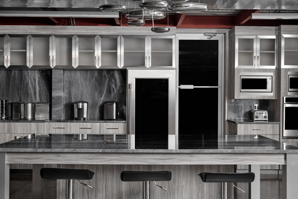 Exempel på ett industriellt grå grått kök, med en undermonterad diskho, släta luckor, grå skåp, granitbänkskiva, grått stänkskydd, rostfria vitvaror, betonggolv, en köksö och grått golv