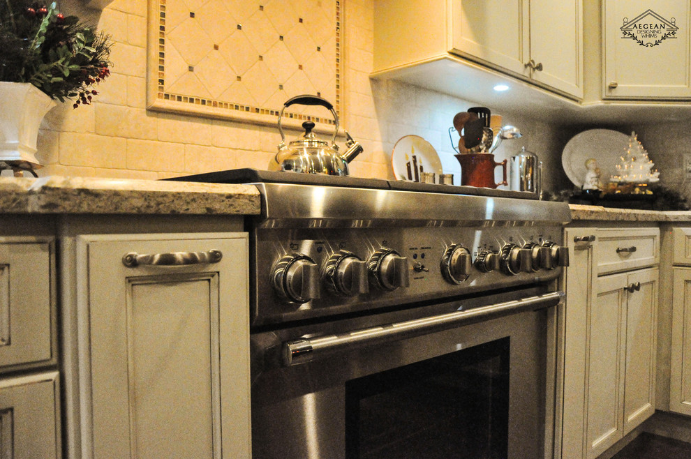Klassisk inredning av ett mellanstort kök, med luckor med infälld panel, granitbänkskiva, beige stänkskydd, stänkskydd i keramik, rostfria vitvaror, en köksö, en enkel diskho och vita skåp