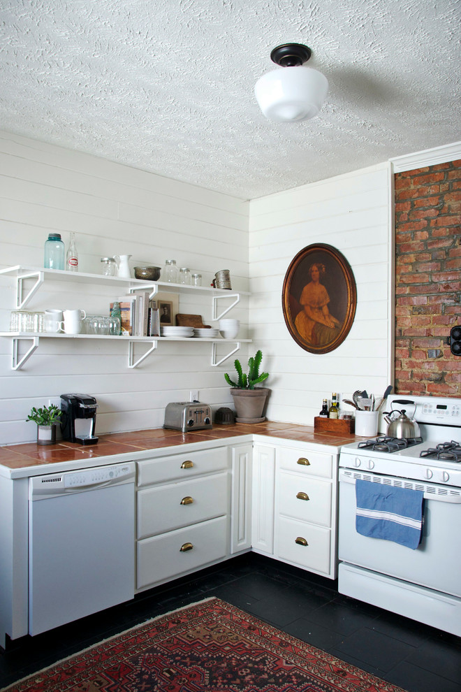 Foto på ett lantligt l-kök, med vita skåp, kaklad bänkskiva, vita vitvaror och öppna hyllor