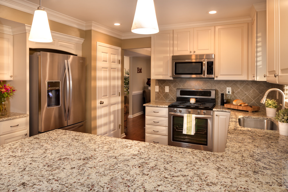 Small transitional u-shaped eat-in kitchen photo in Charlotte with a single-bowl sink, raised-panel cabinets, white cabinets, granite countertops, brown backsplash, ceramic backsplash and stainless steel appliances